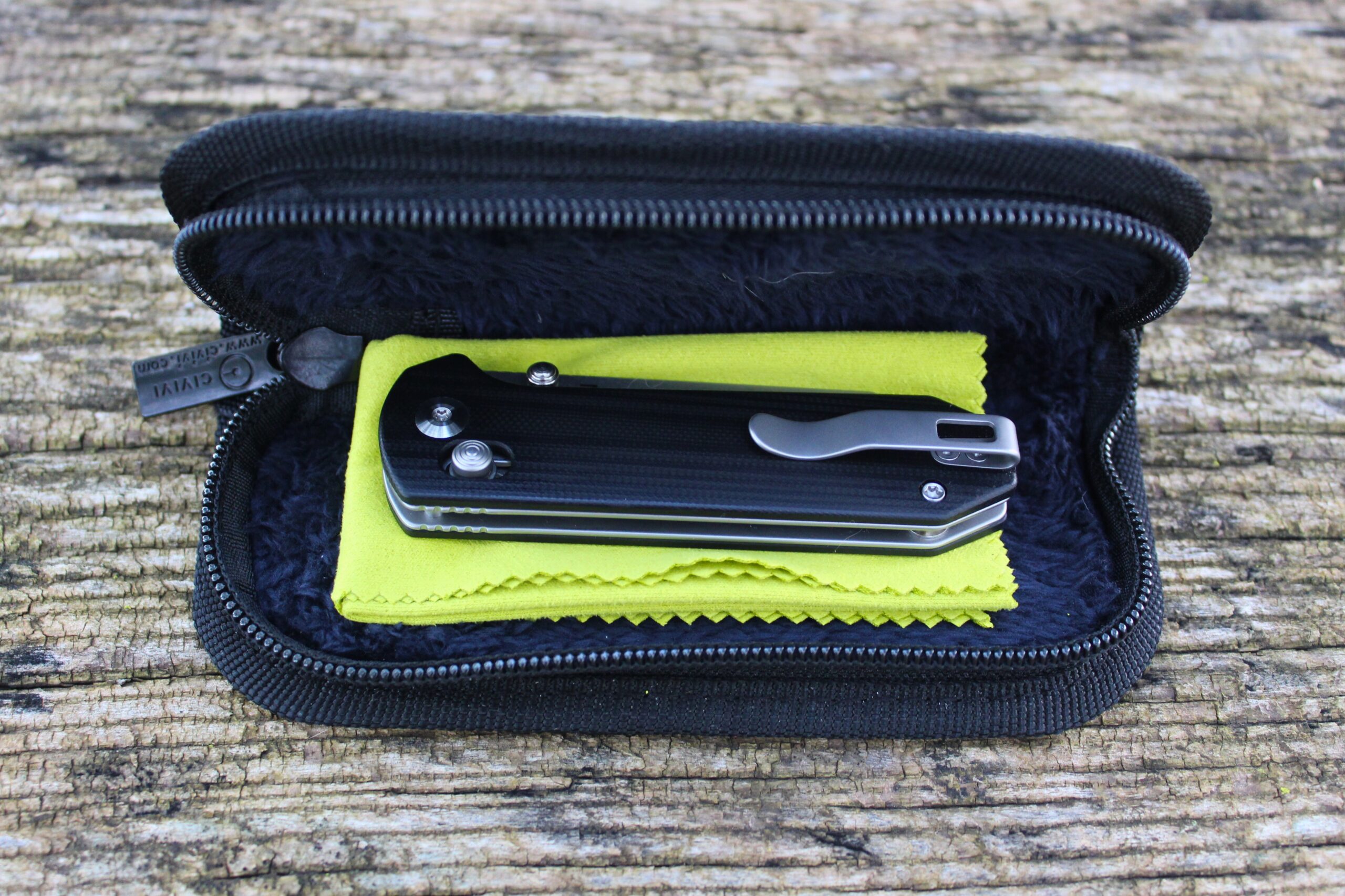 The Civivi Yonder G10 Pocket Knife in the case sitting on the cleaning cloth