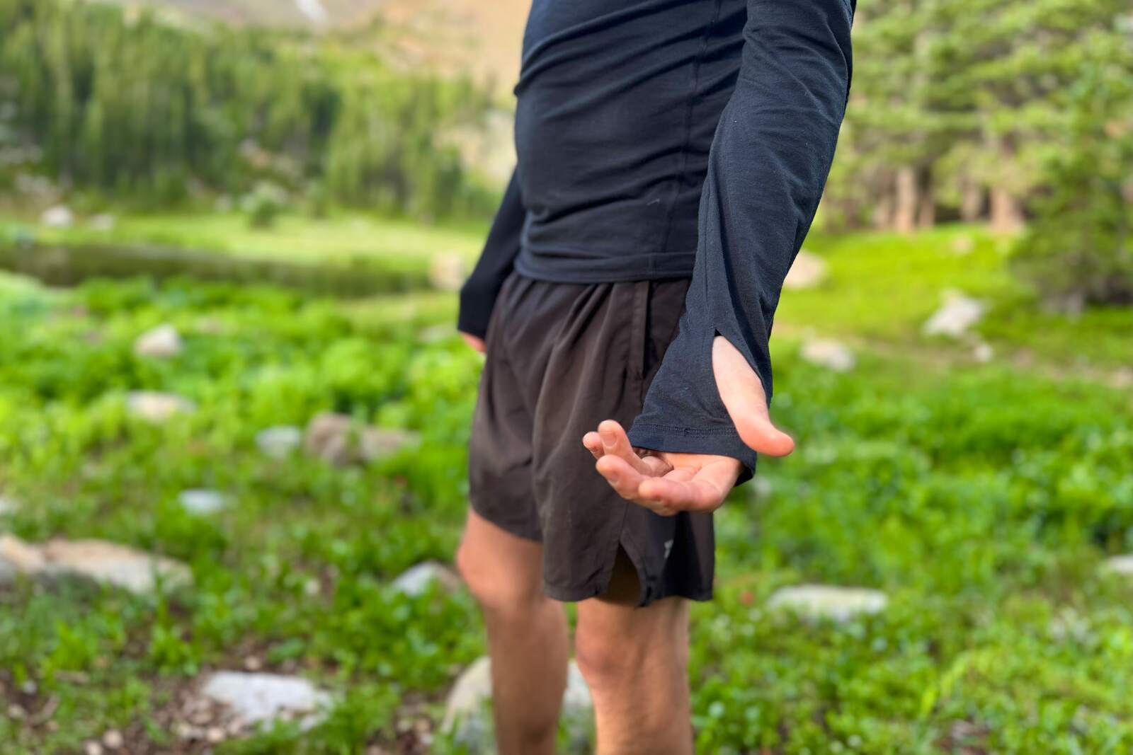 a hiker in a black base layer shows the thumb loops on his sleeves