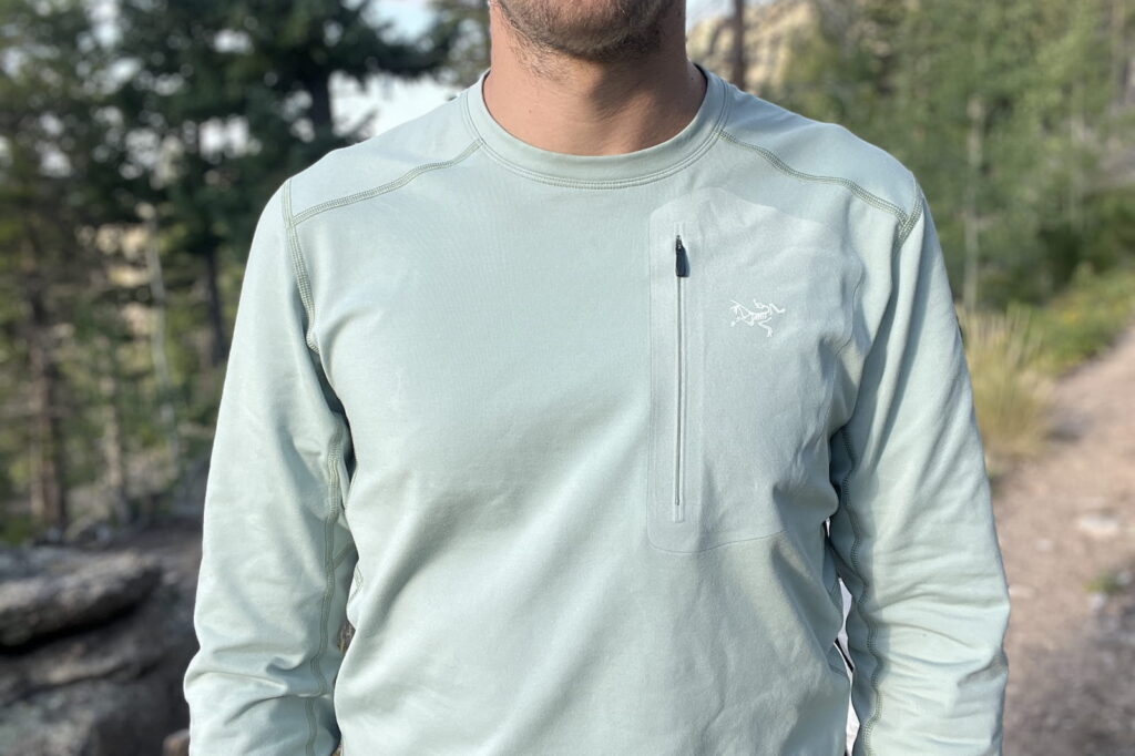 a front torso shot of a hiker in the woods wearing a light blue base layer.