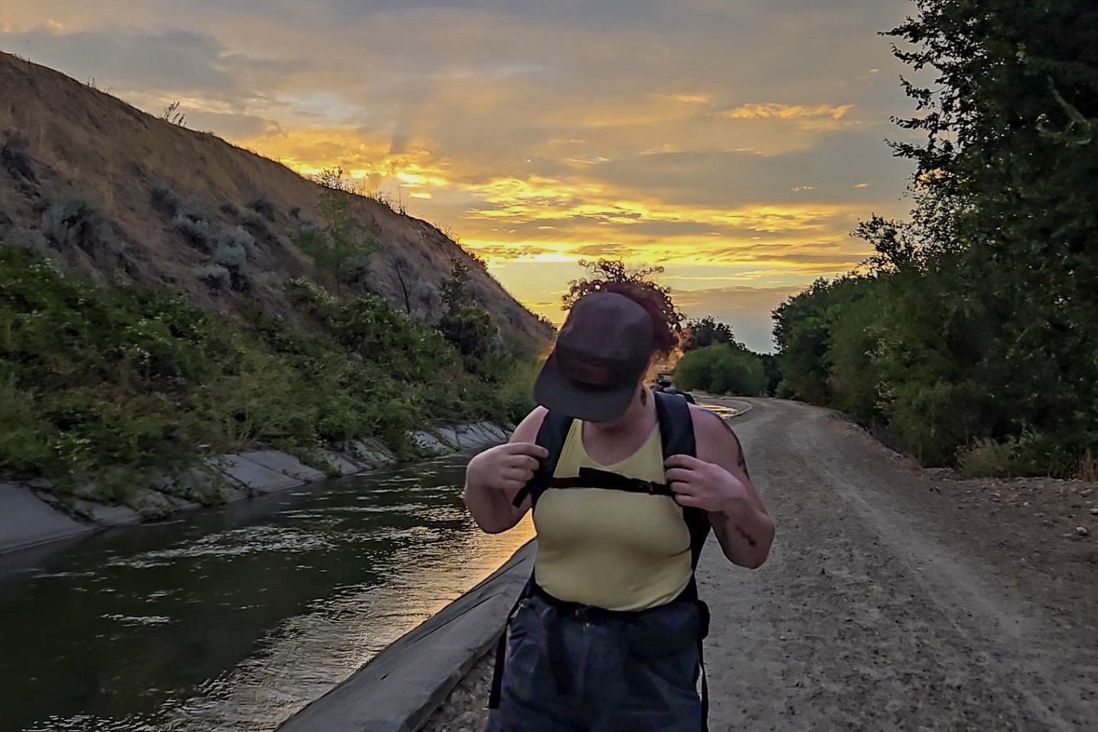 Person wearing a black Dethalon Quechua day pack faces the camera and shows the sternum strap.