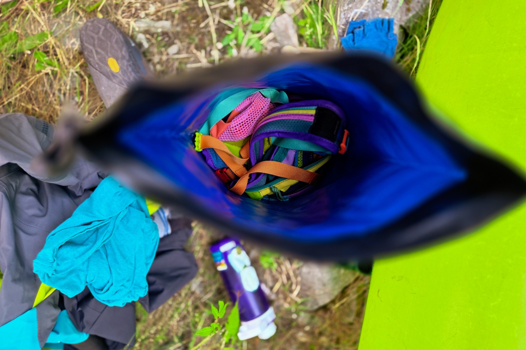 Looking into a roll-top dry bag, we see a colorful Cotopaxi day pack in the bottom.