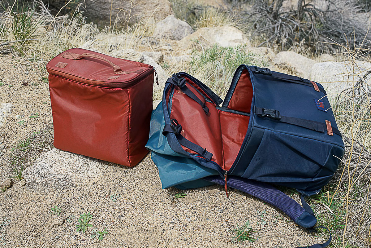 The removable cooler insert of the REI Cool Trail Split Pack sits on the ground next to the rest of the pack.