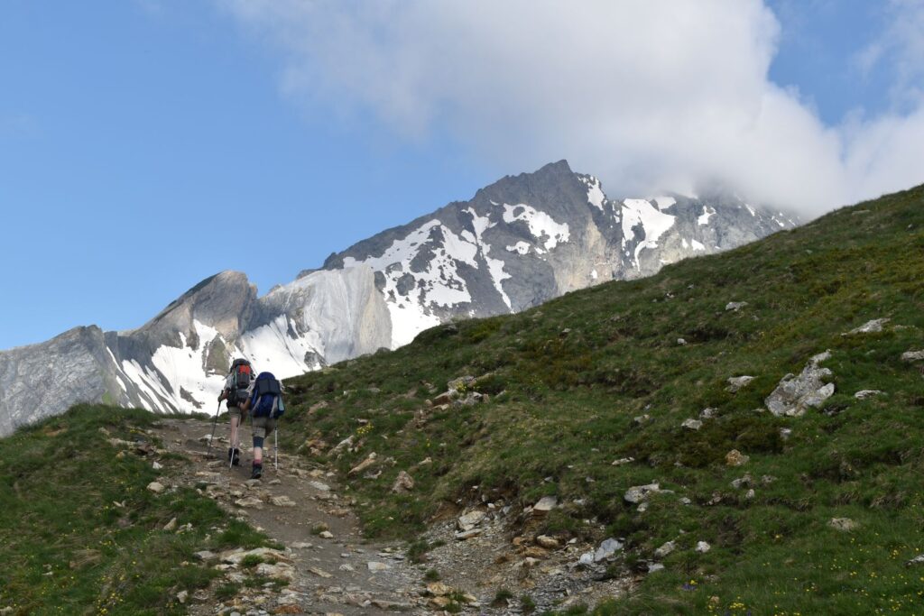 A pair of backpackers nears the crest of a steep hill before turning right onto the next switcback
