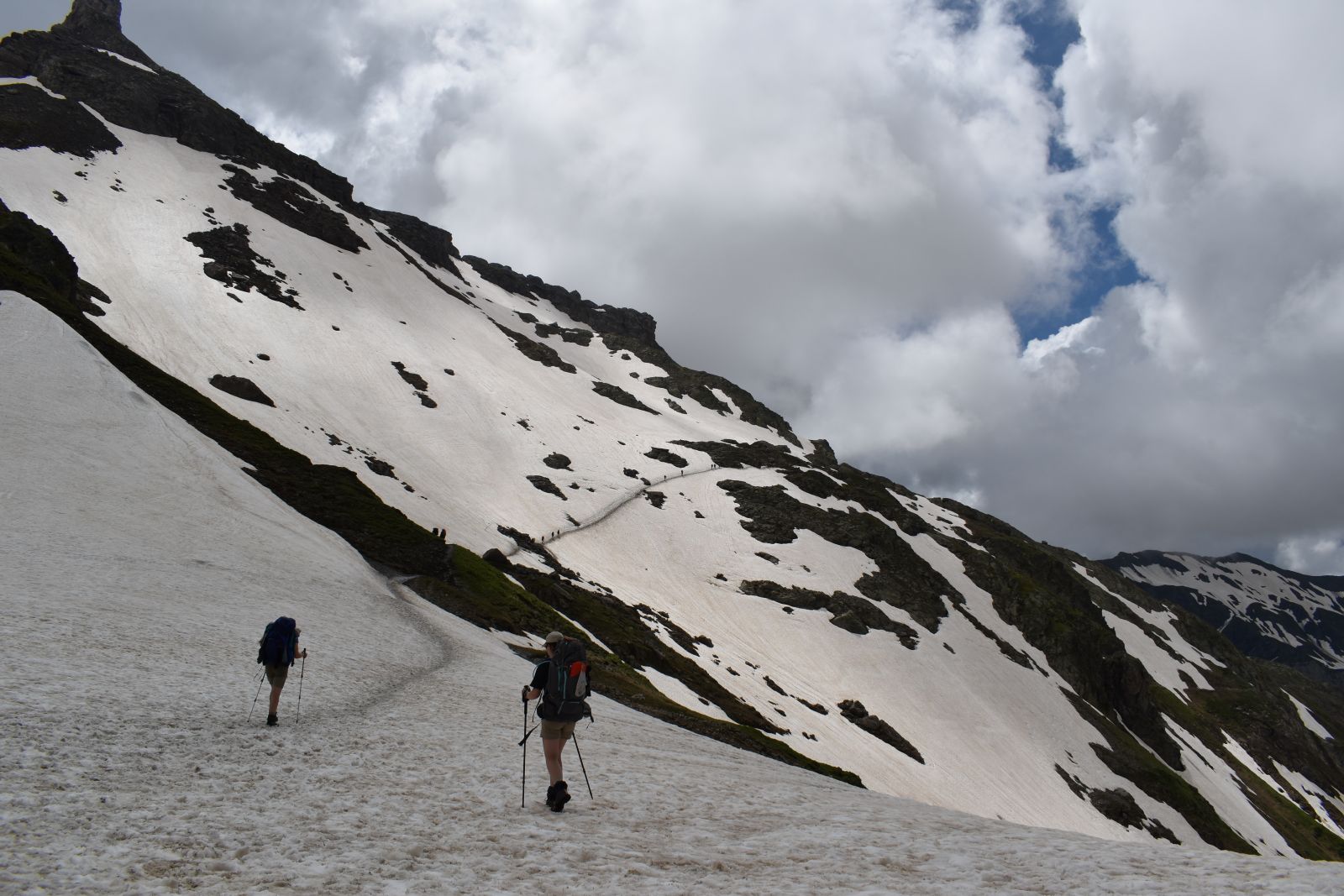 Hikers begin a long, snowy stretch of trail high above the normal TMB route