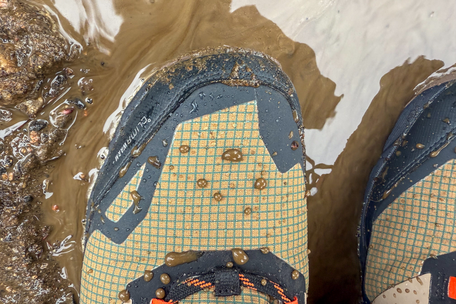 Mud and water beading on the toe box of the Adidas Terrex Skychaser AX5 Mid GTX Climawarm+, demonstrating the waterproof performance of the Climawarm upper.