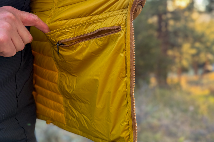 Inside view of the Cotopaxi Fuego jacket showing a zippered interior pocket for storage.