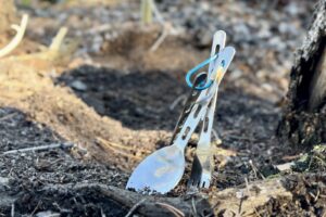 a 3-piece utensil set stabbed into dirt