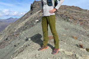 A closeup of green pants on an alpine ridge.