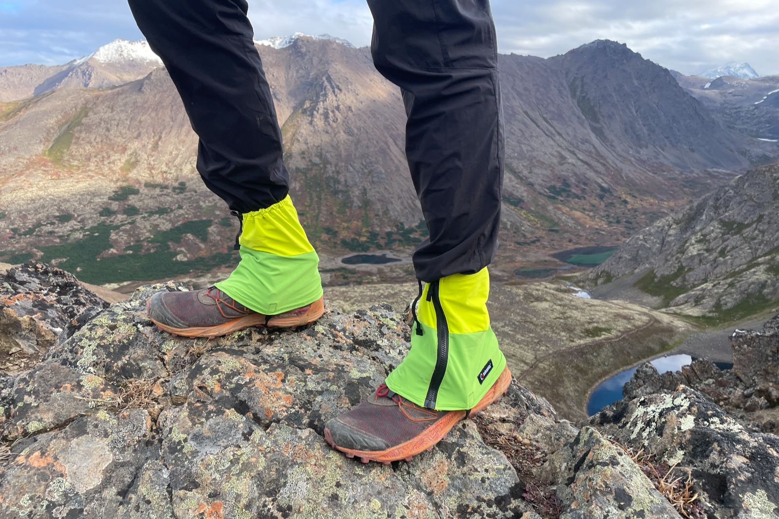 A closeup of hikng giaters with a mountainous background.