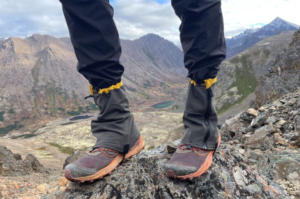 A closeup of gaiters with a mountain view in the background.
