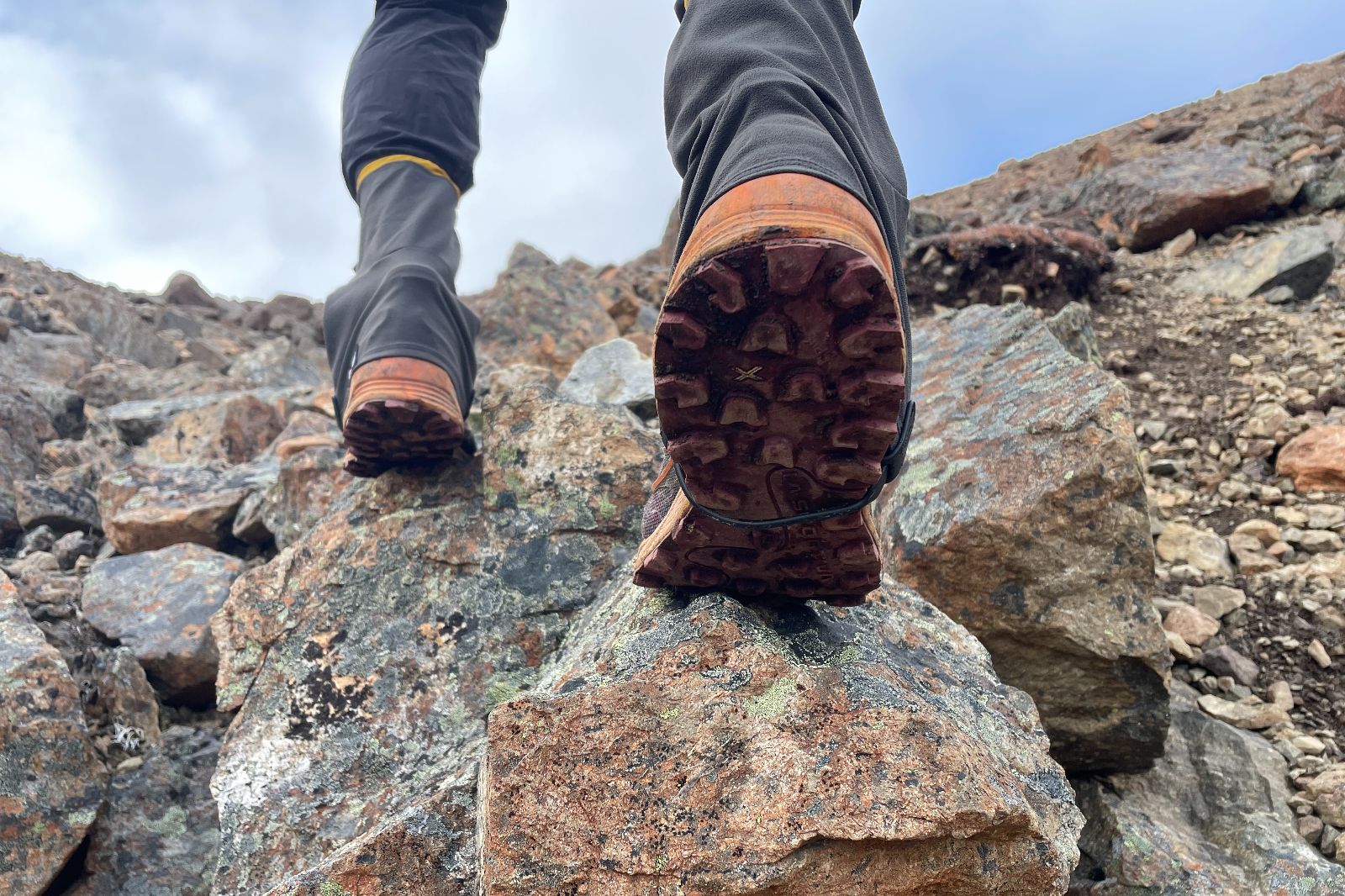 A closeup underneath shoes wearing gaiters