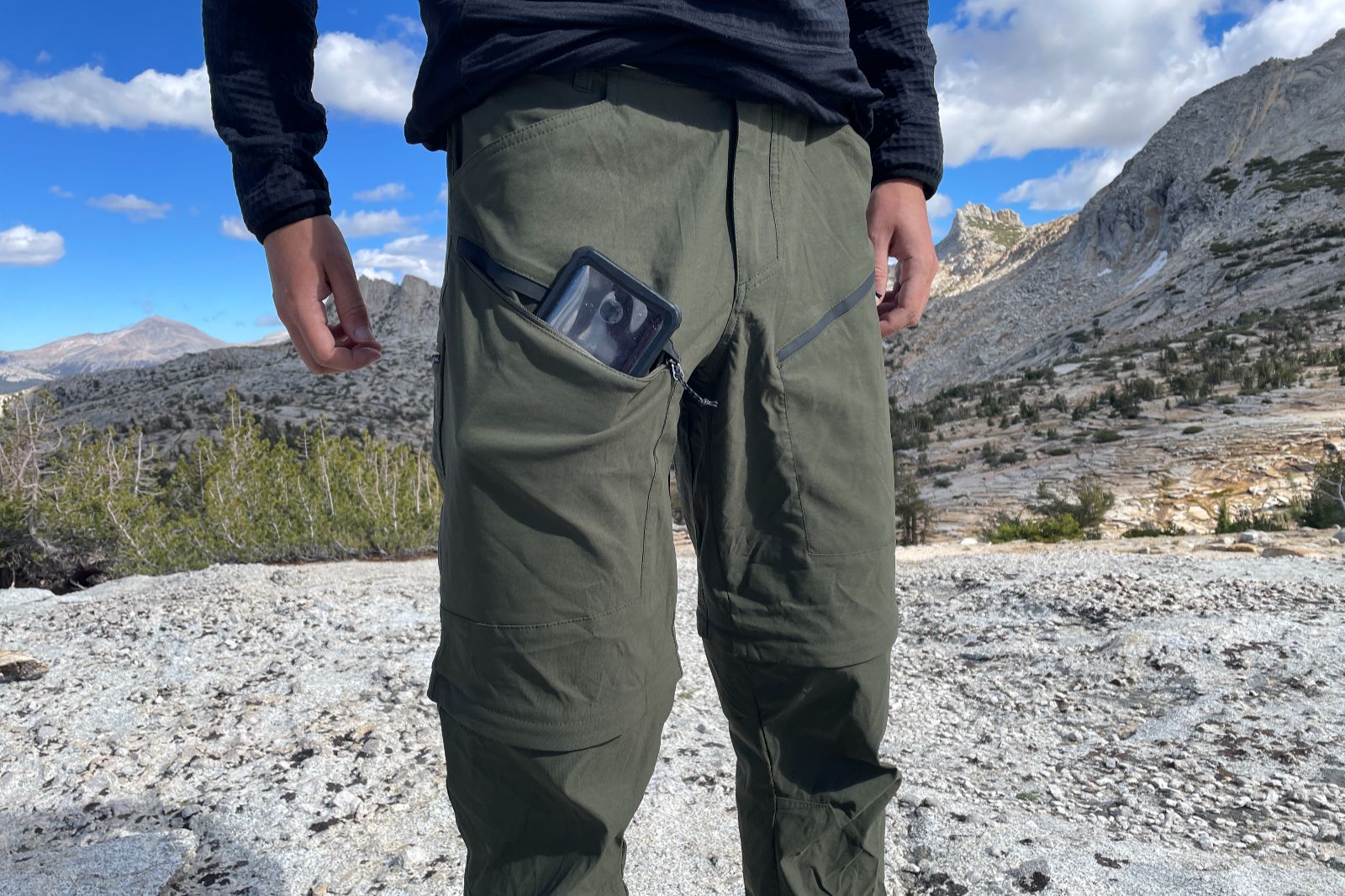 A closeup of the pockets on a pair of pants with a phone in one.