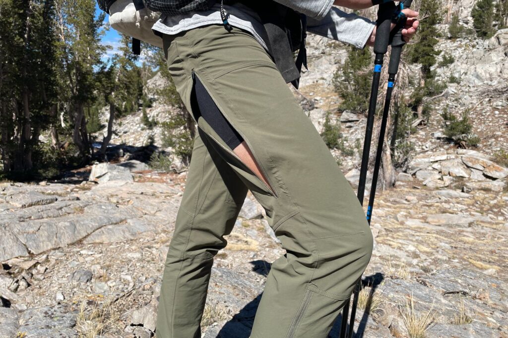 A closeup of the side vents on a pair of green hiking pants.