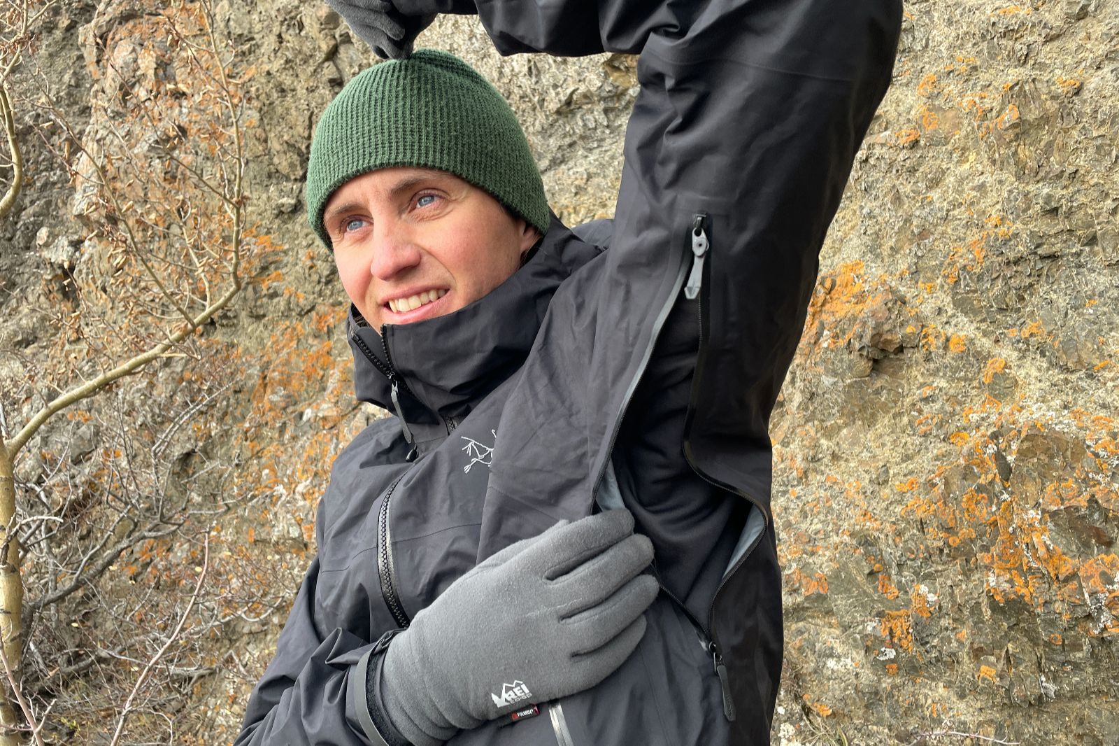 A closeup of a man showing unzipped pit bents of his rain jacket.
