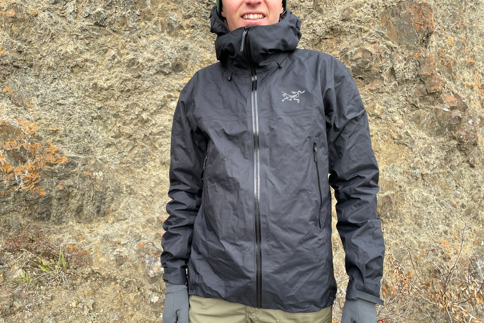 A closeup of the front of a black rain jacket.