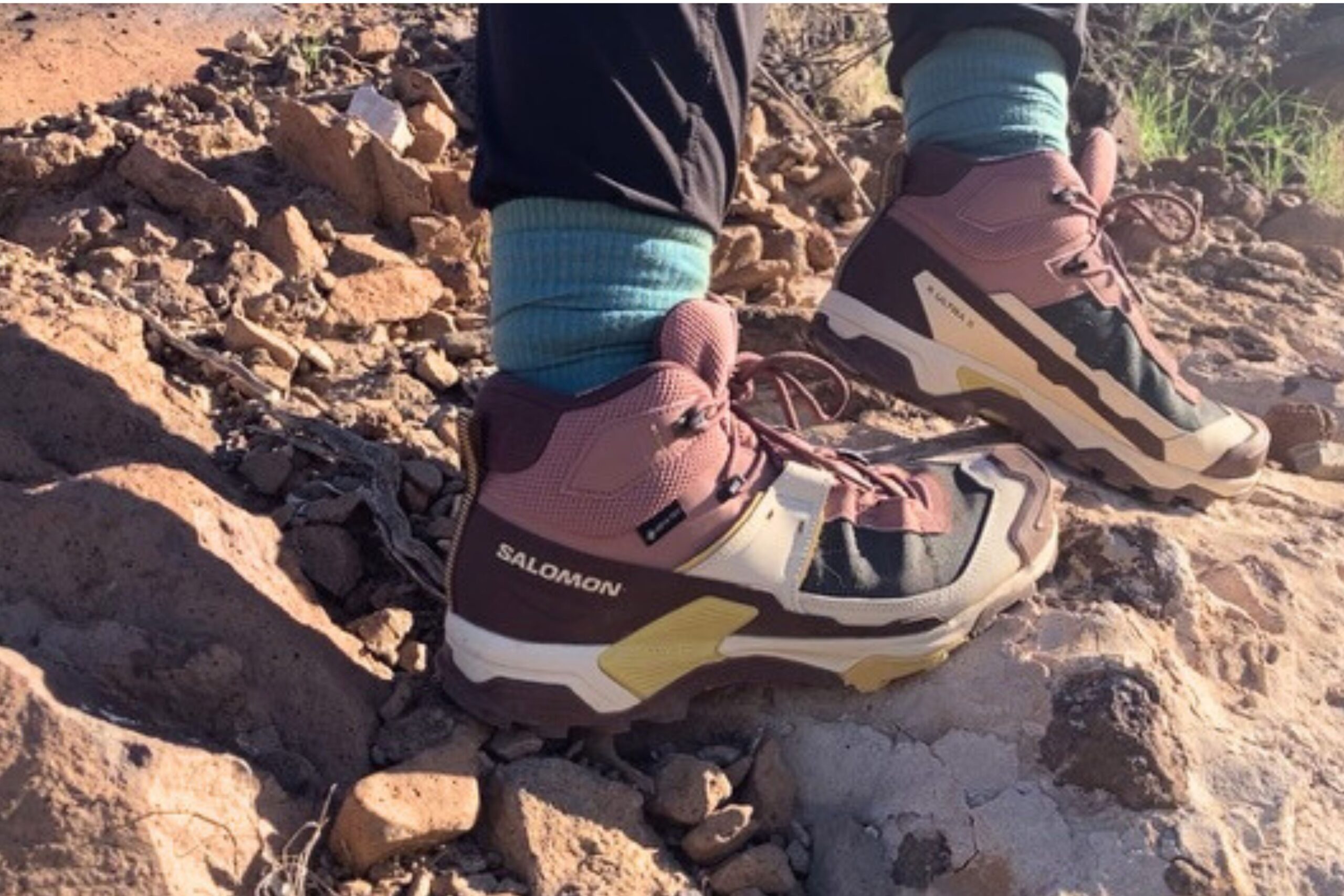 A hiker passing over a rocky trail wearing the Salomon X Ultra 5 GTX women's hiking boots