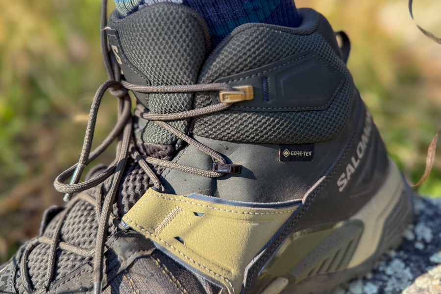 A close-up of the Salomon X Ultra 5 Mid GTX hiking boot’s lacing system and padded ankle collar, highlighting the Gore-Tex logo and breathable mesh fabric.