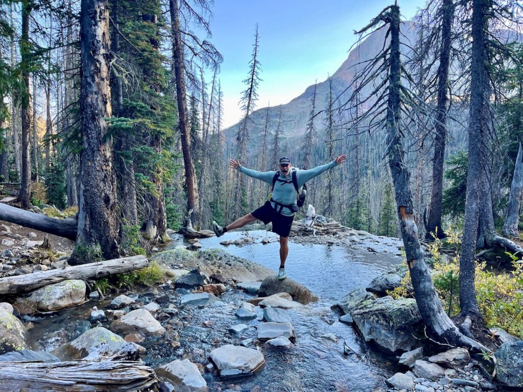 The author balances on a rock while crossing a small steam in the San Juan Mountains
