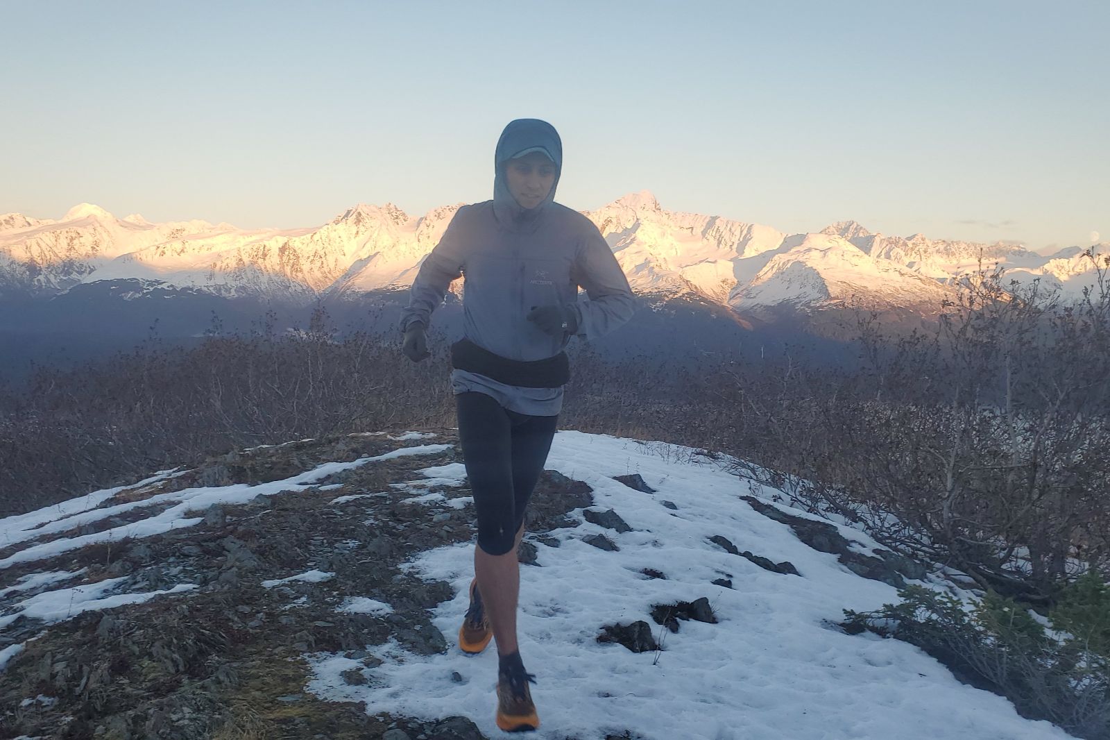 A man runs at sunset in the alpine.