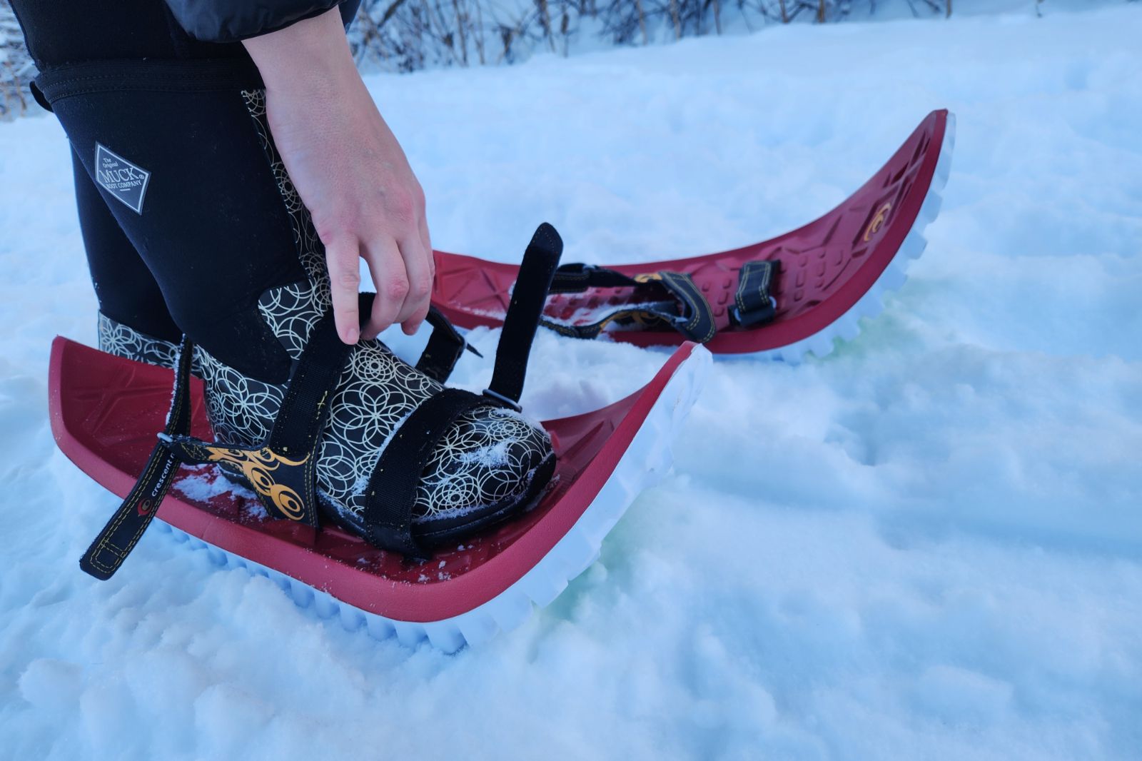 A closeup of velcro straps of snowshoes being put on.