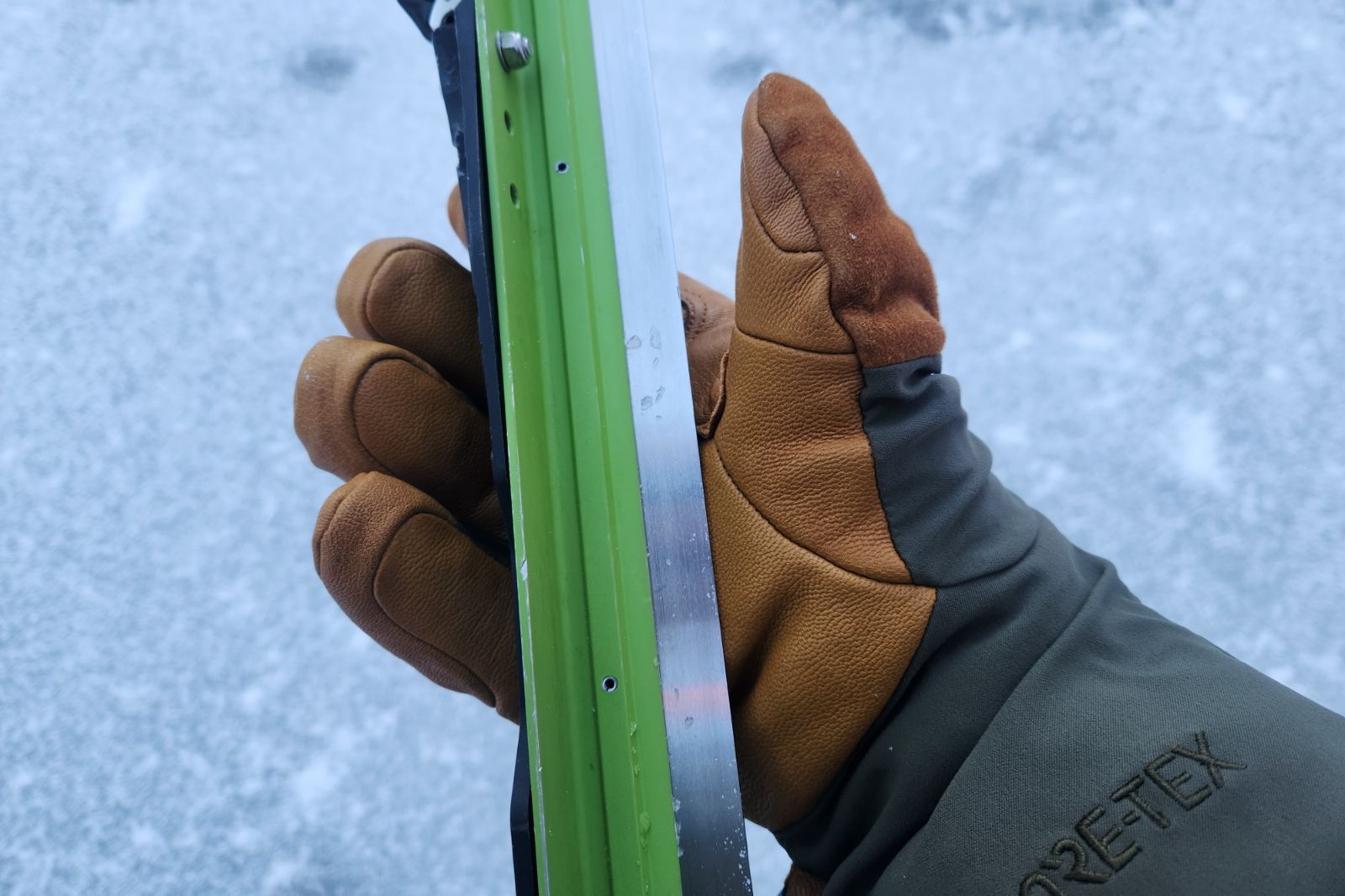 A closeup of leather palmed gloves holding a pair of ice skates.