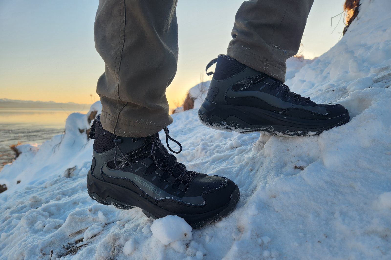 A closeup of winter boots hiking up a snowy trail.