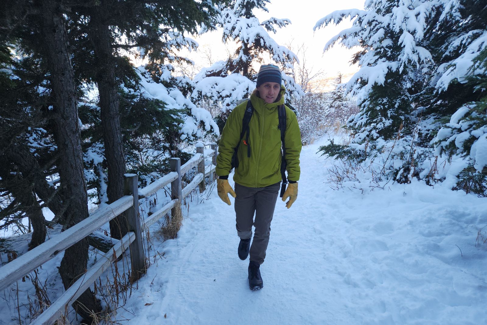 A man hikes up a snowy trail.