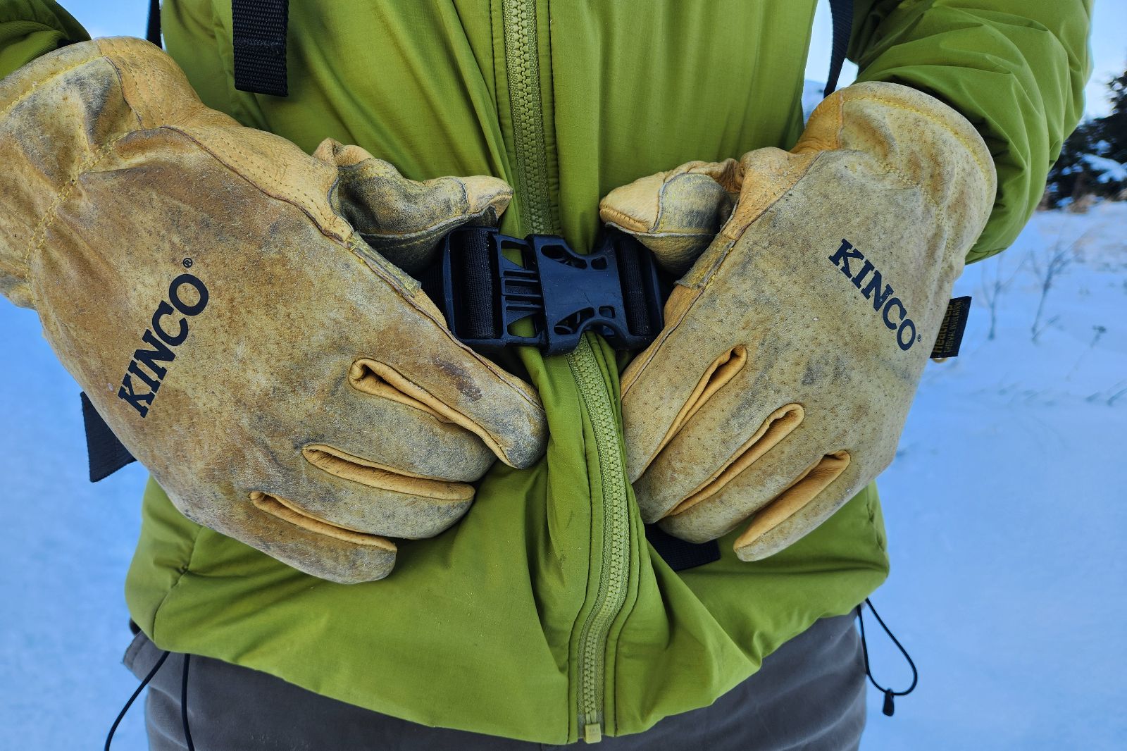 A closeup of gloves buckling a belt.