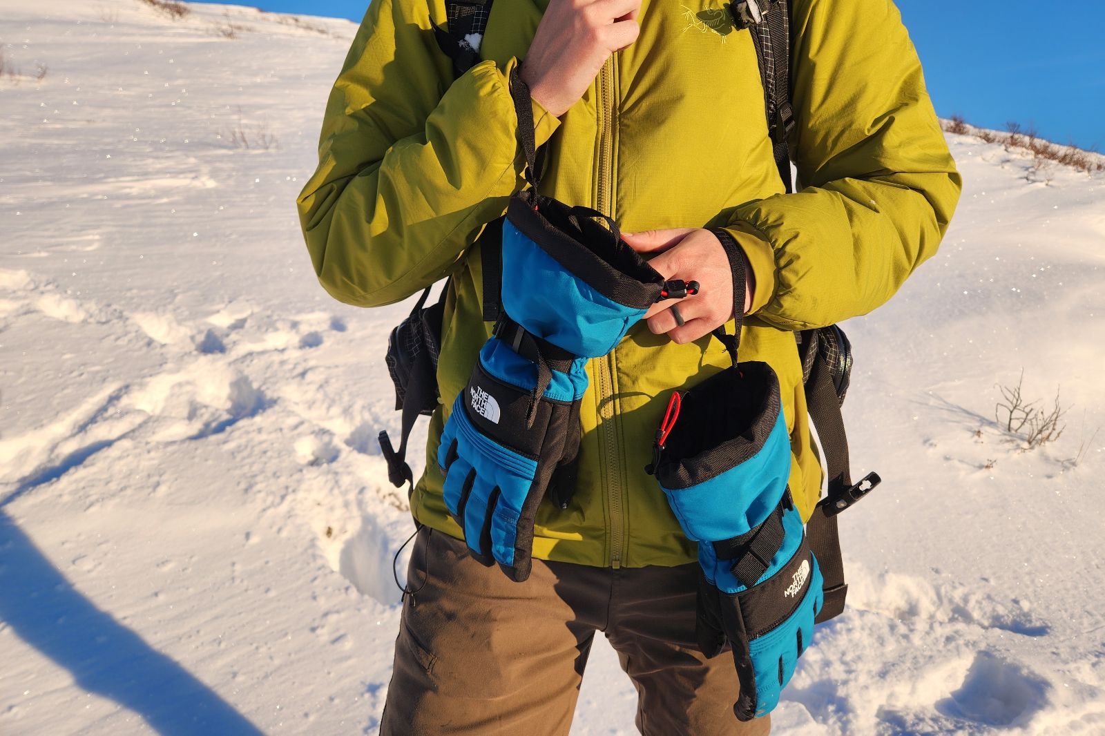 A pair of gloves dangles by their leashes.