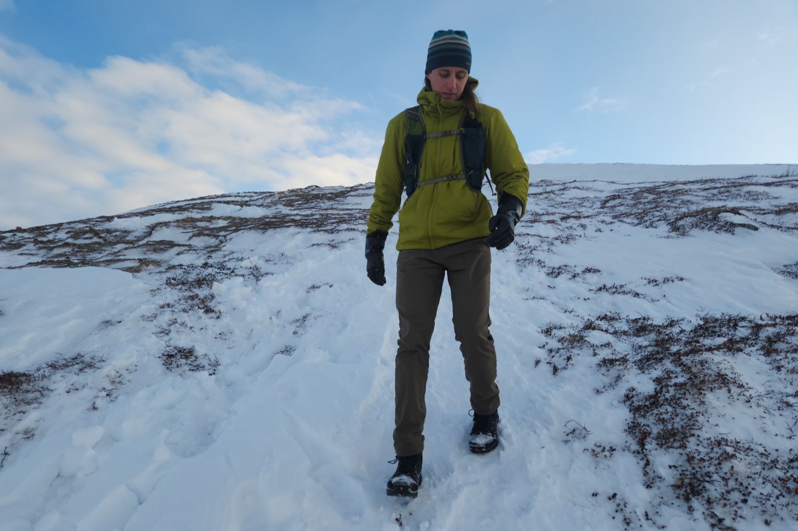 A man hikes down a winter alpine slope.