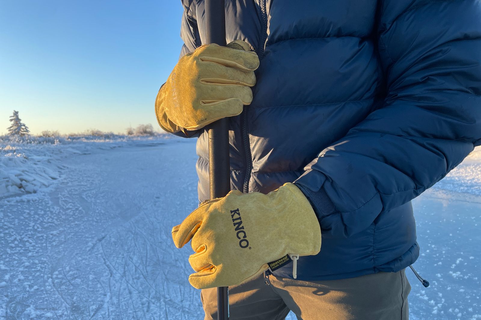 A closeup of gloves grapsing a pole.
