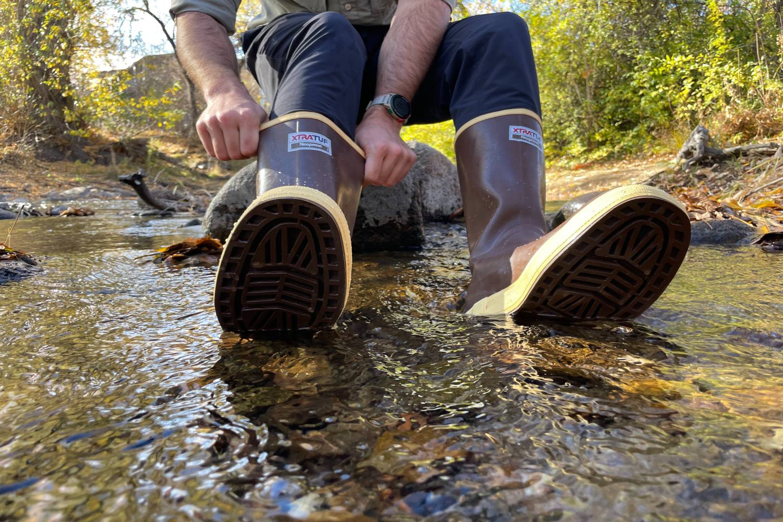 Adjusting the fit of the 15" Legacy Boots while partially submerged in a stream.