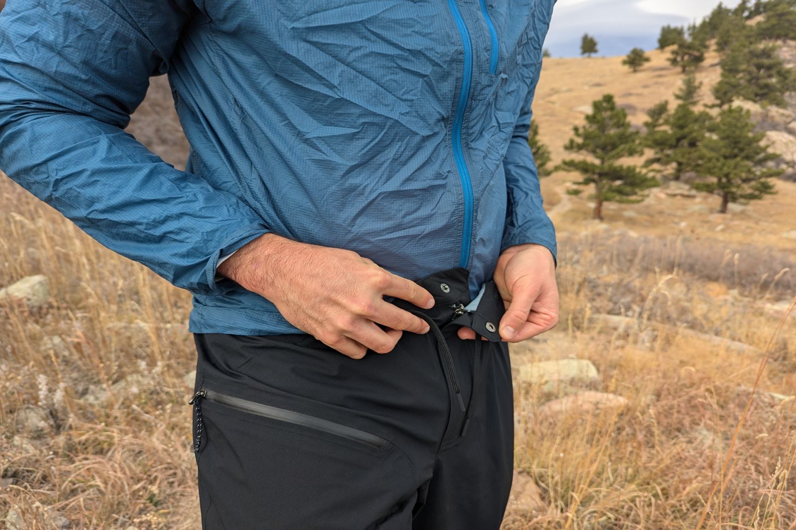 Showing the snap buckle waist closure on the Mountain Hardware Stretch Ozonic rain pants.