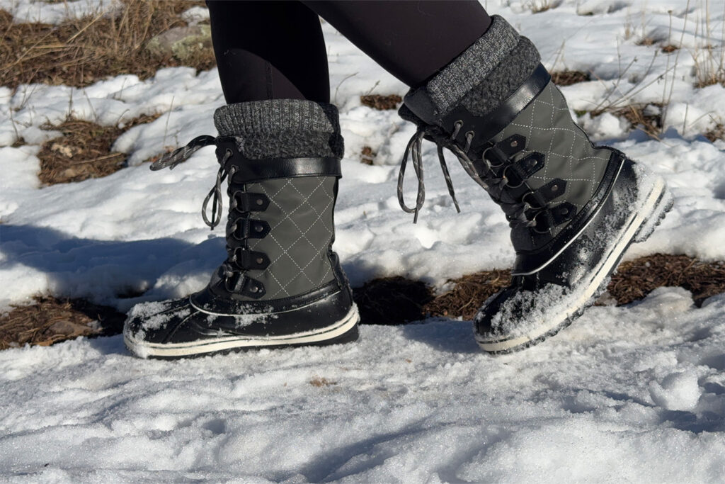 Close up of the Dream Pairs boots as the person wearing them walks by the camera on a snowy trail,