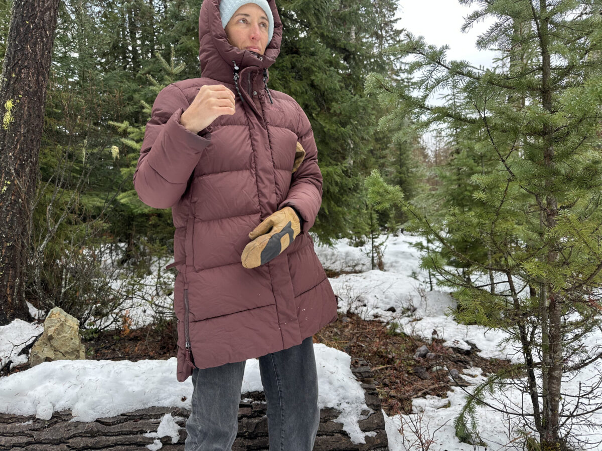 women wearing a down parka in a snowy forest