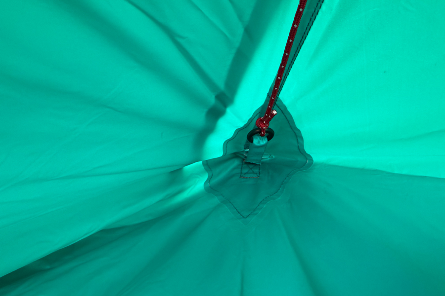 Close-up of the Trango 2’s fly fabric from the inside, showing a reinforced attachment point with stitching and a red guyline anchored to a grommet.