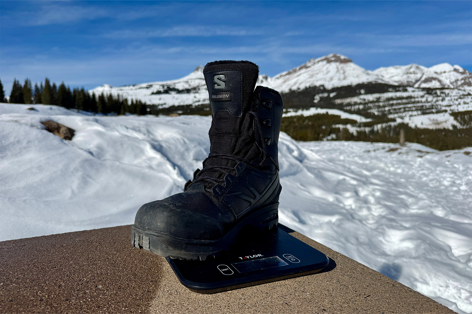 A Toundra boot sits on a kitchen scale. There are mountains in the background.