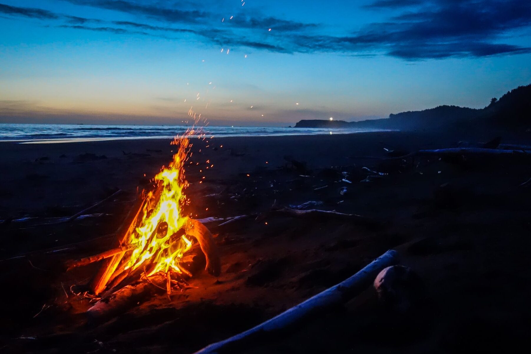 sunset on a beach with a fire