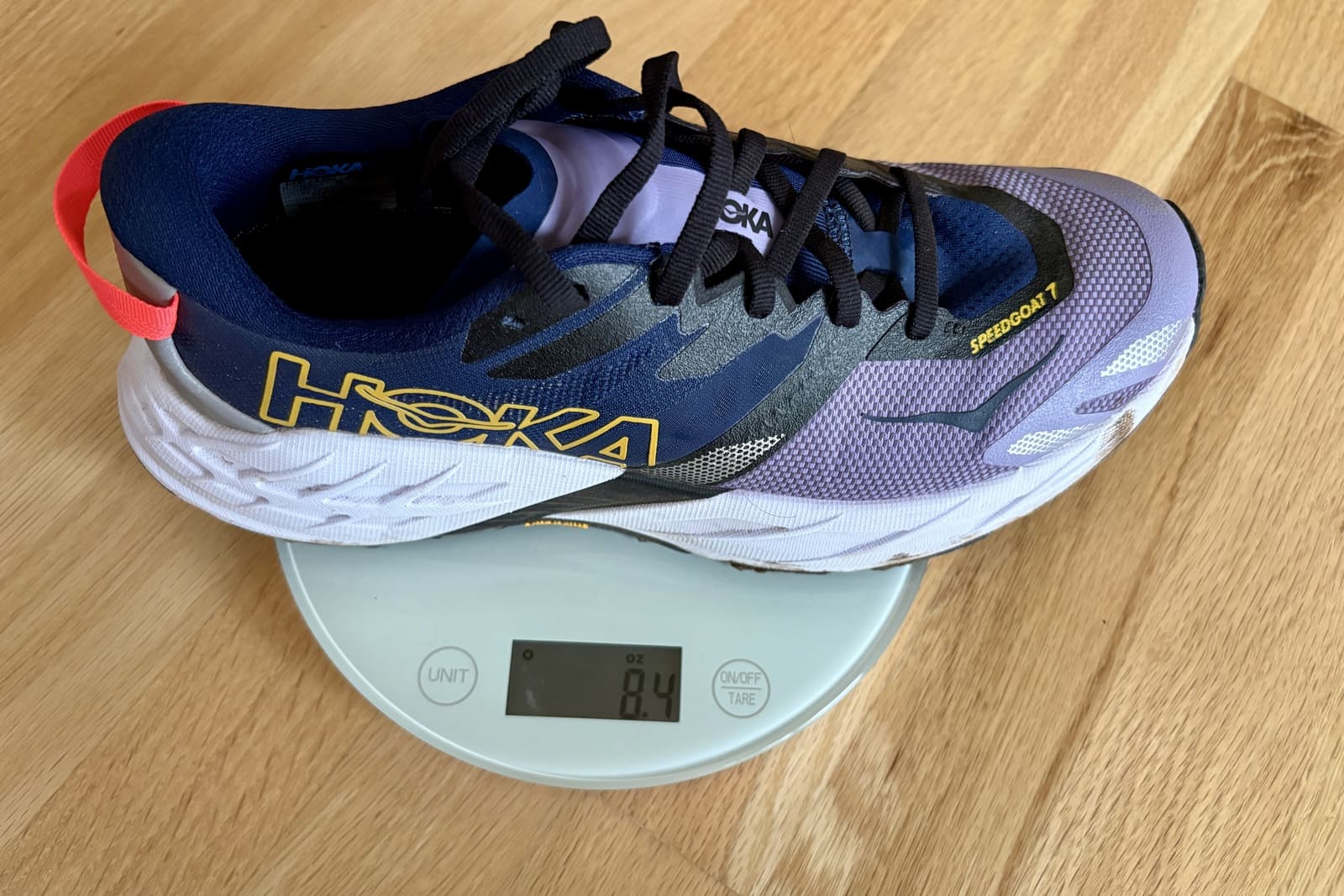 A closeup showing the weight of a running shoe on a scale.