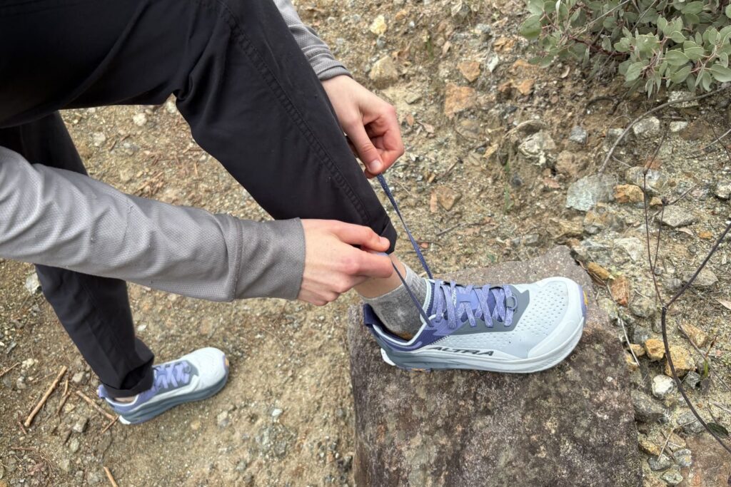 A woman ties the laces on her shoes.