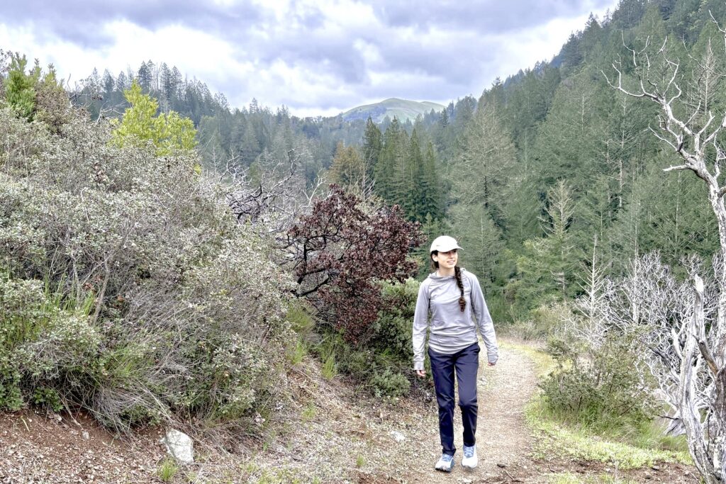 A woman hikes up a trail in the forest.
