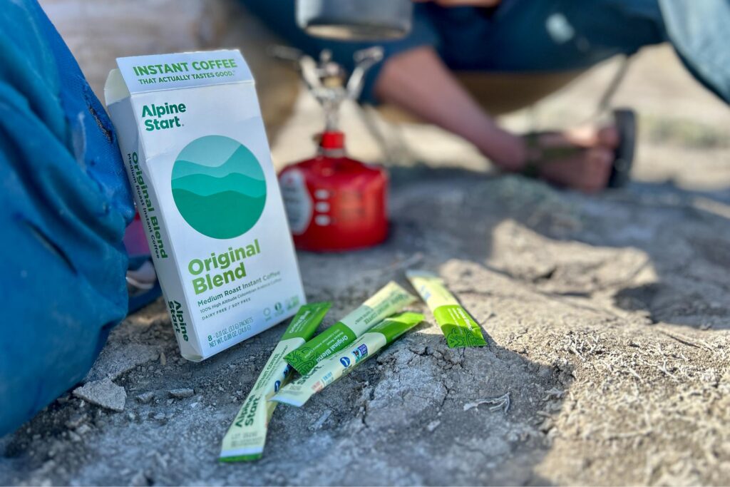 Up-close image of Alpine Start instant coffee box with packages in front of it