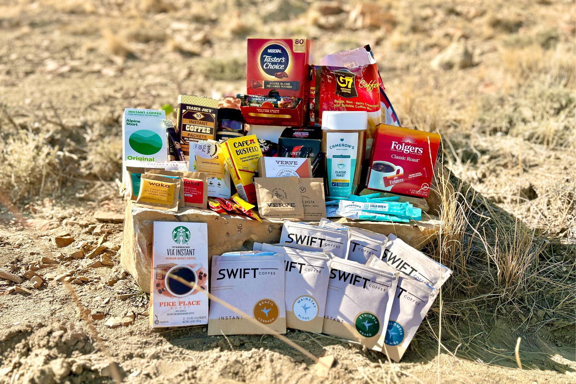 An image of 12 different instant coffee brands staged on a rock