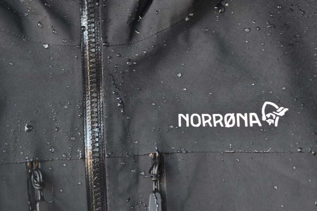 Water beads off the black shell of our Norrona trollveggen GORE-TEX Pro Light jacket