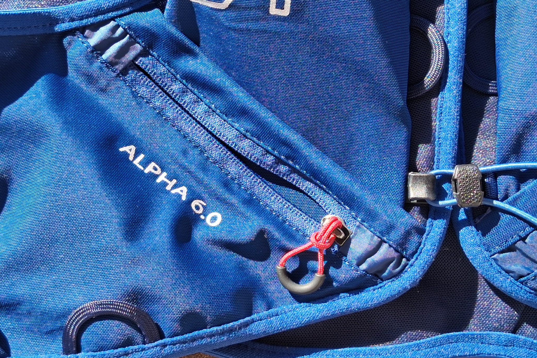Close-up image of the zippered security pocket on the UltrAspire Alpha 6.0 running vest.
