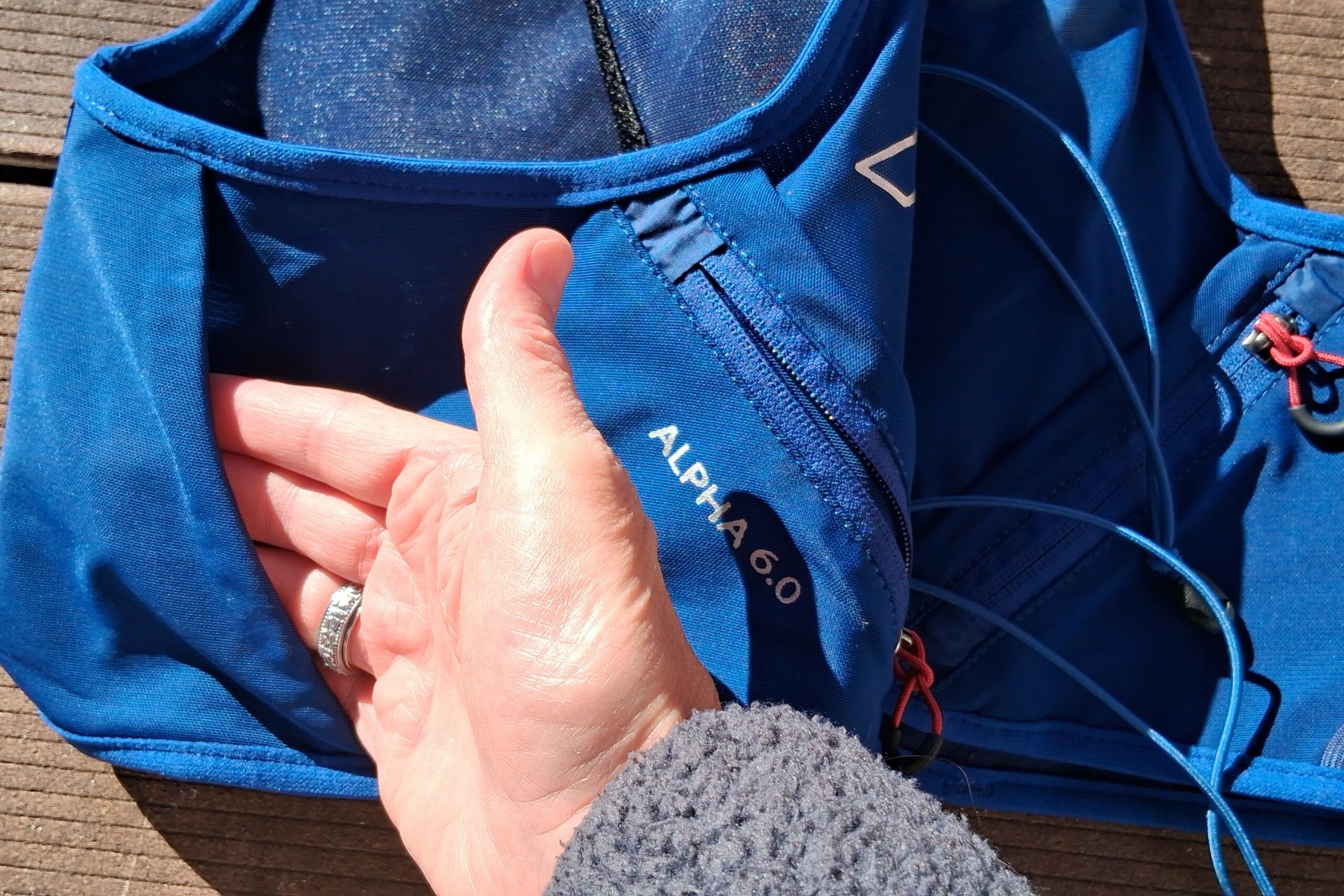 Close-up image of the pass-through lumbar pocket on the UltrAspire Alpha 6.0 running vest.