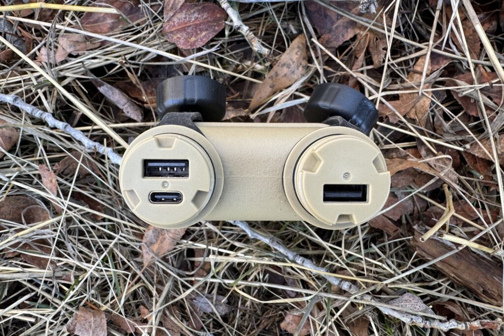 Close up of the ports on the Nestout power bank. It is sitting in some leaves and grass.