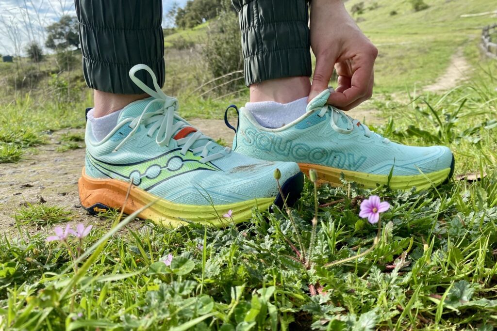 A woman adjusts the tongue on her shoe.