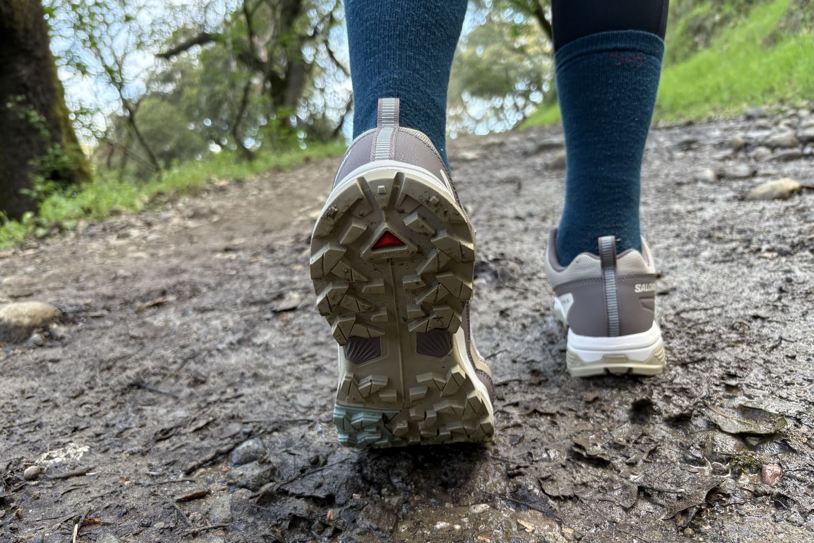 Closeup of the tread on a shoe hiking in the mud.