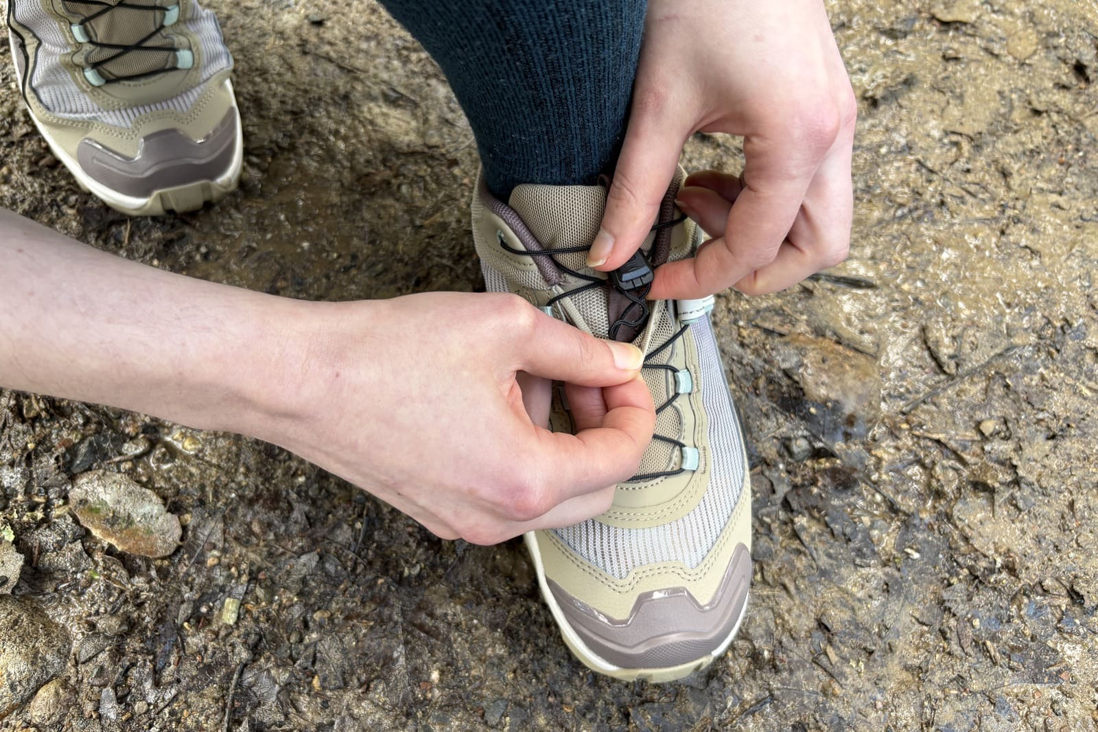 A woman tucks her laces into a pocket in the shoe.